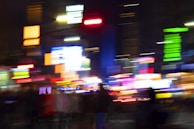 An abstract view of neon lights reflecting on city buildings.