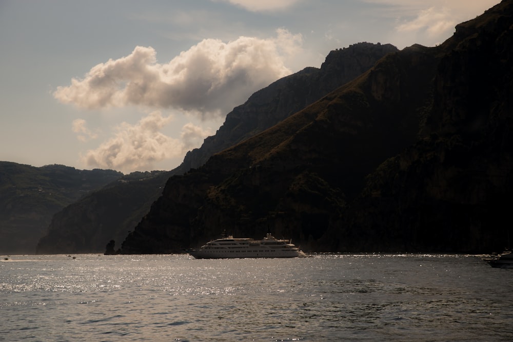 a cruise ship in a body of water with mountains in the background