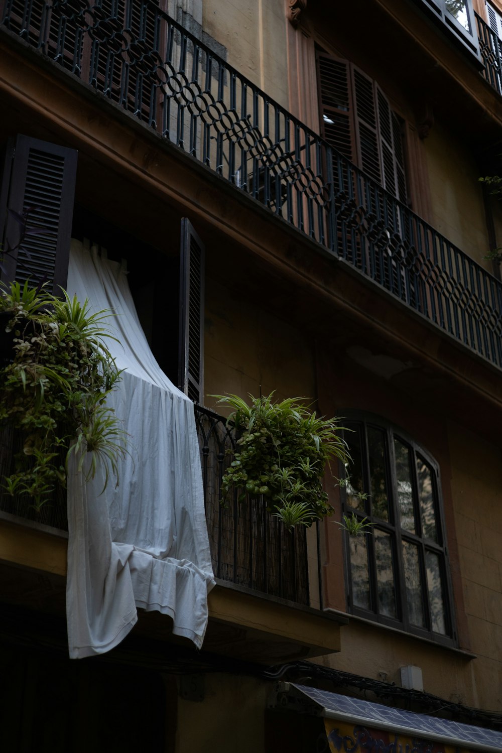 a tall building with balconies and plants on the balconies