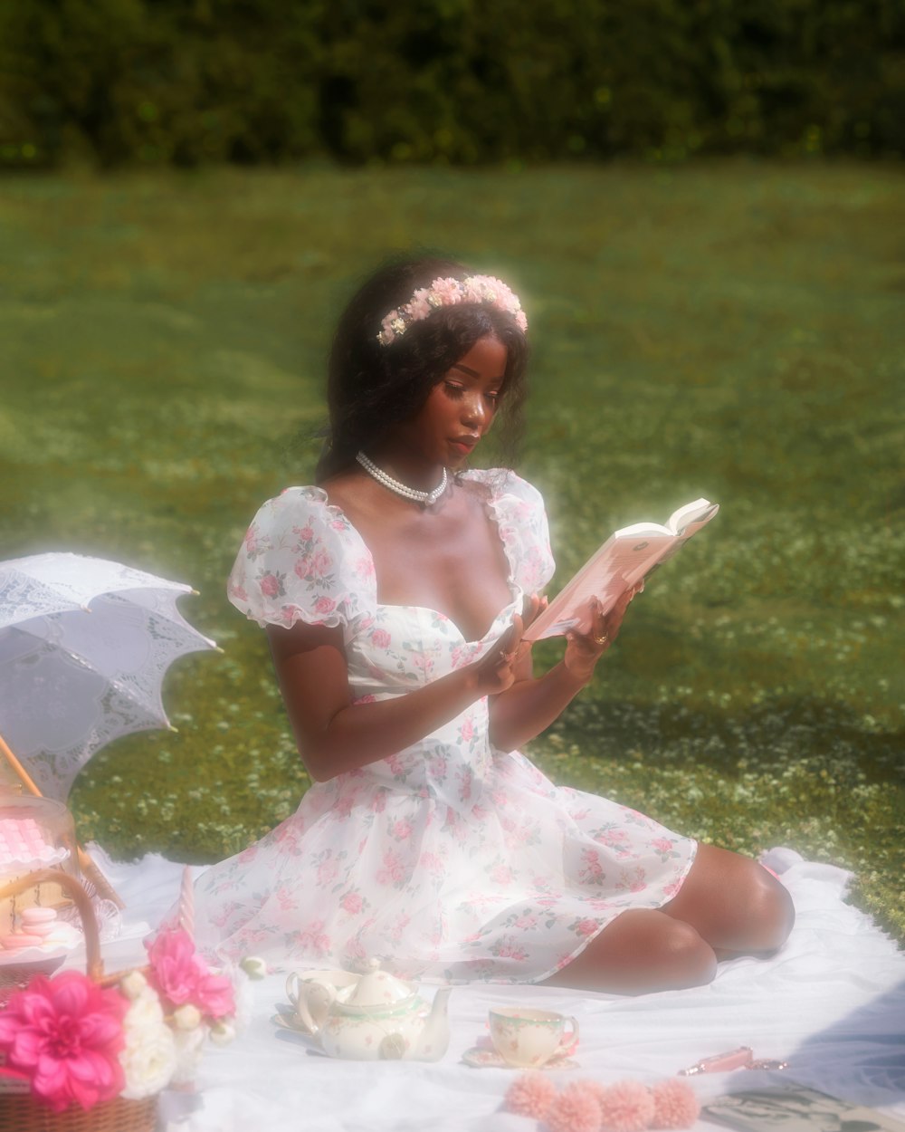 a woman sitting on a blanket reading a book