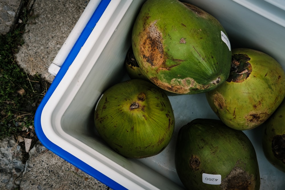 a blue and white container filled with green fruit