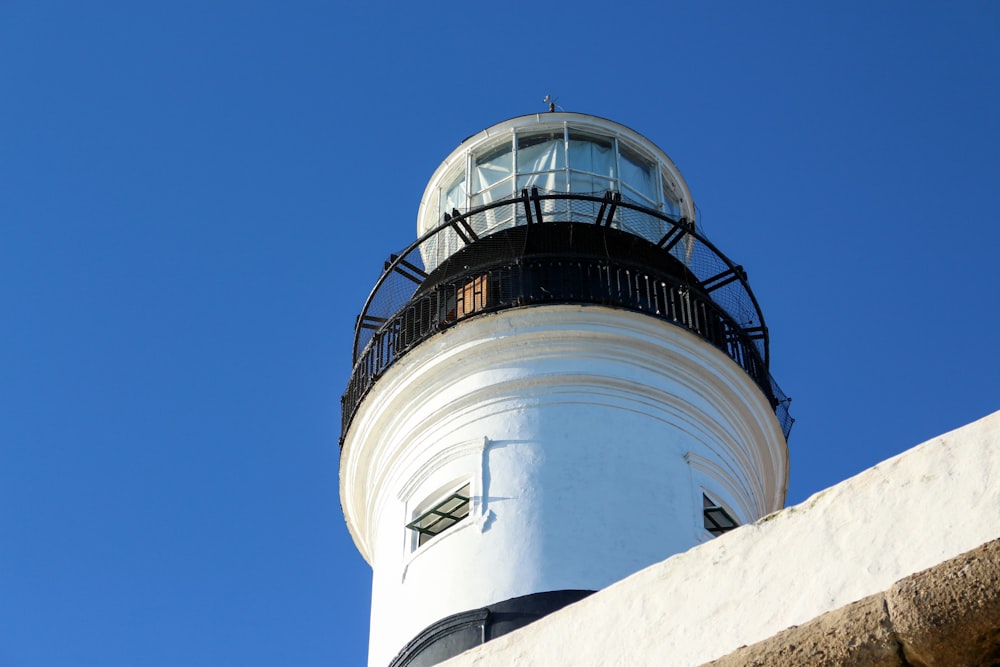 Un faro bianco e nero contro un cielo blu