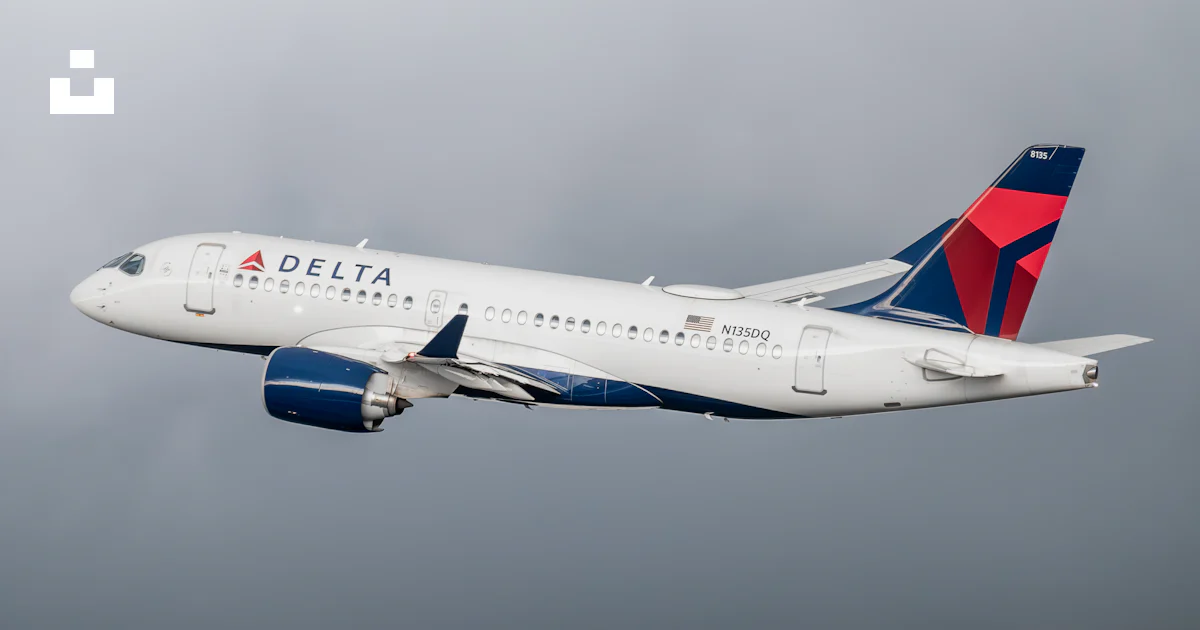 A delta airplane flying in a cloudy sky photo – Free Airplane Image on ...