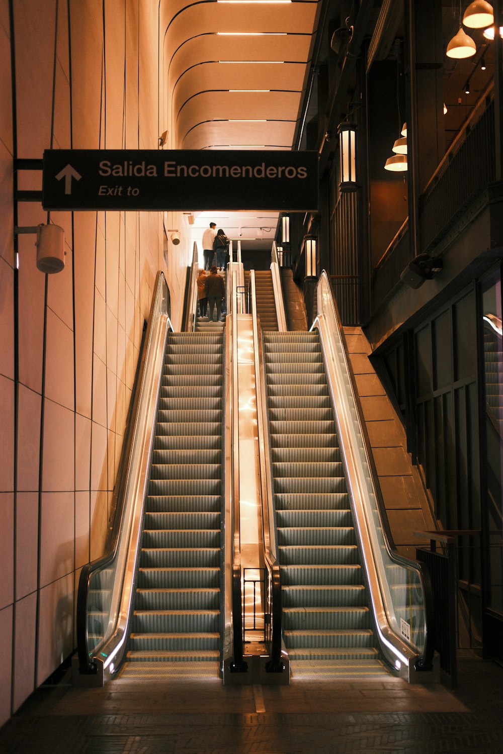 an escalator in a building with a sign above it