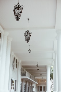 A stylish event entrance framed by white columns and gold lanterns glowing warmly