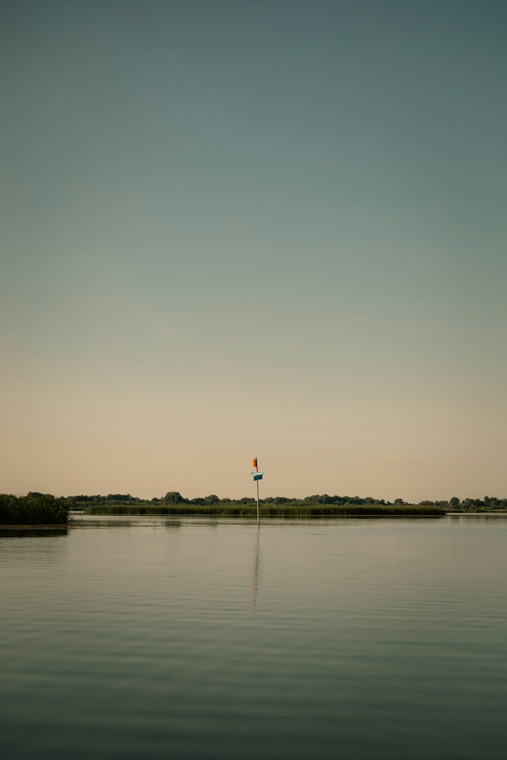 a body of water with a flag on a pole in the middle of it