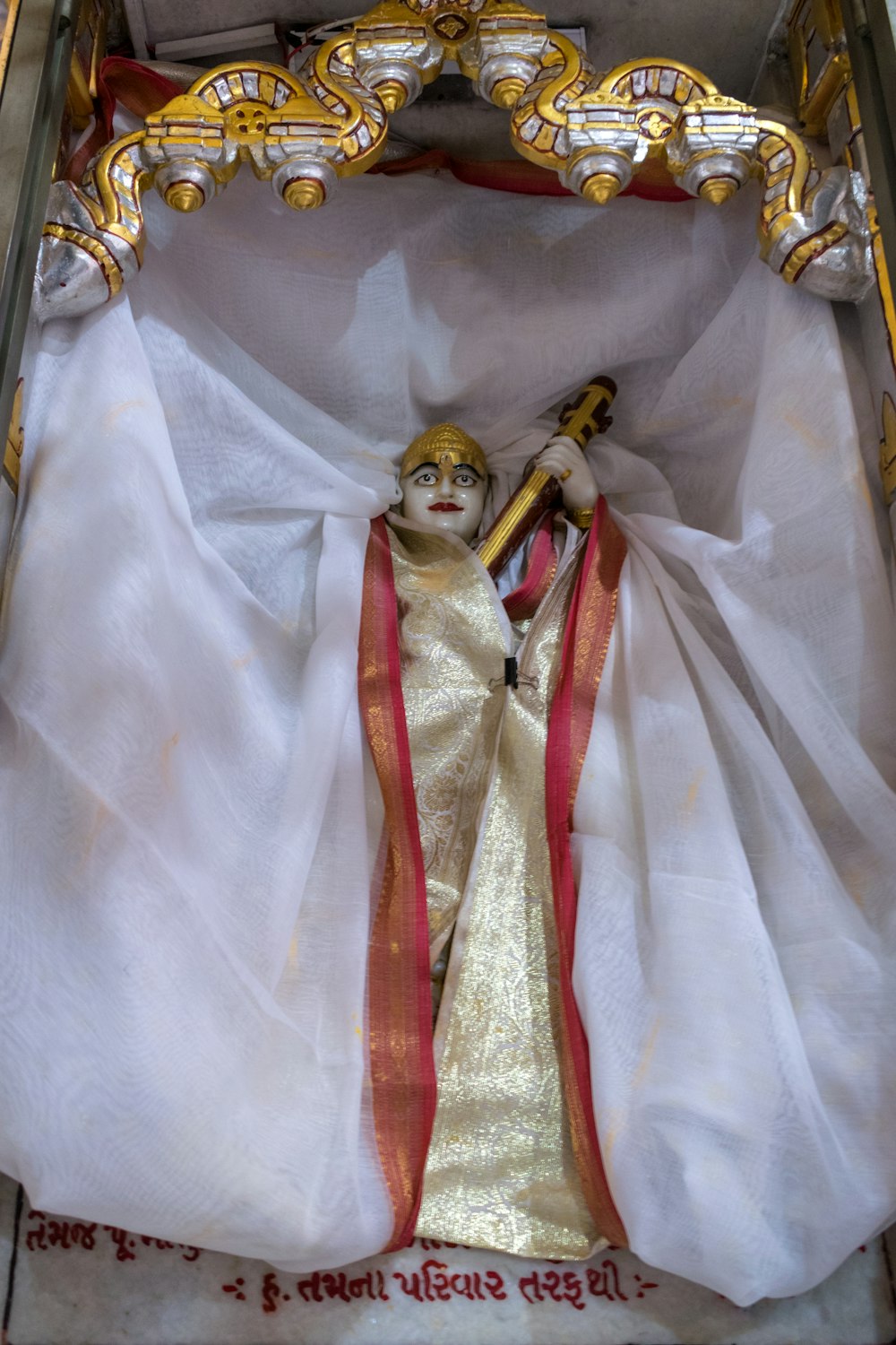 a statue of a person in a white and gold outfit