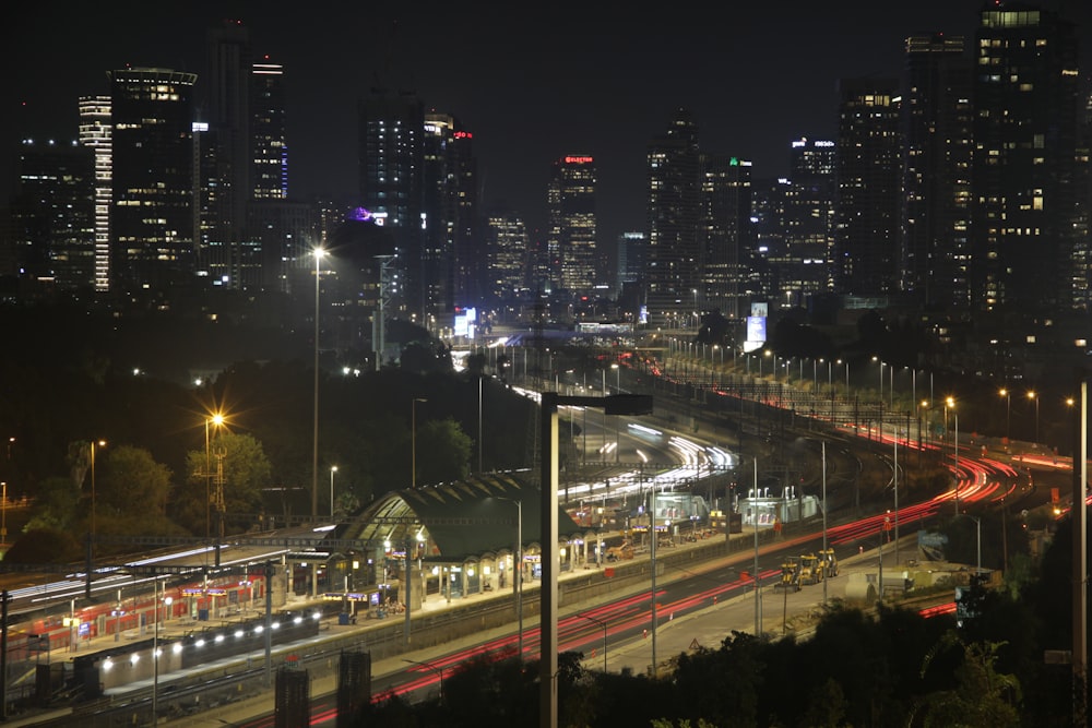 a city skyline at night with a train on the tracks