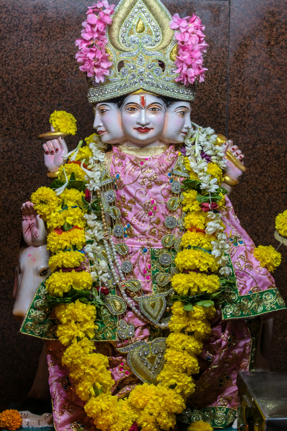 a statue of a hindu god with flowers around it