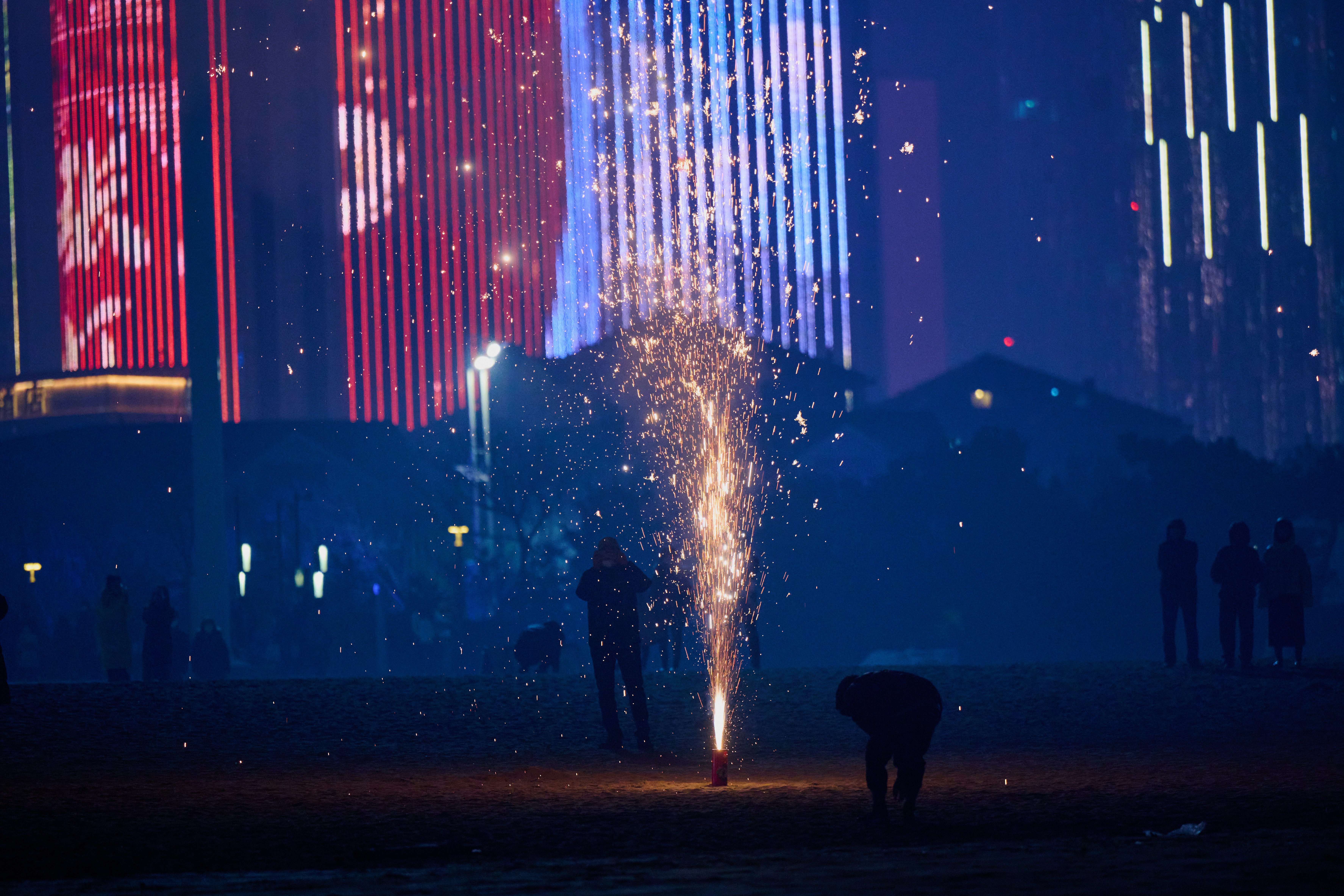Osoba stojąca przed zamkiem z fajerwerkami w tle.