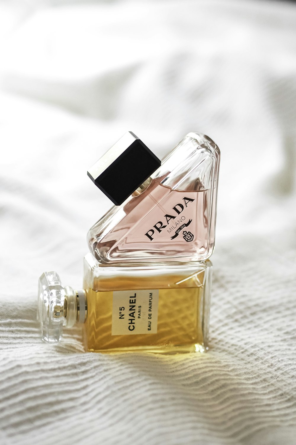a bottle of perfume sitting on top of a bed