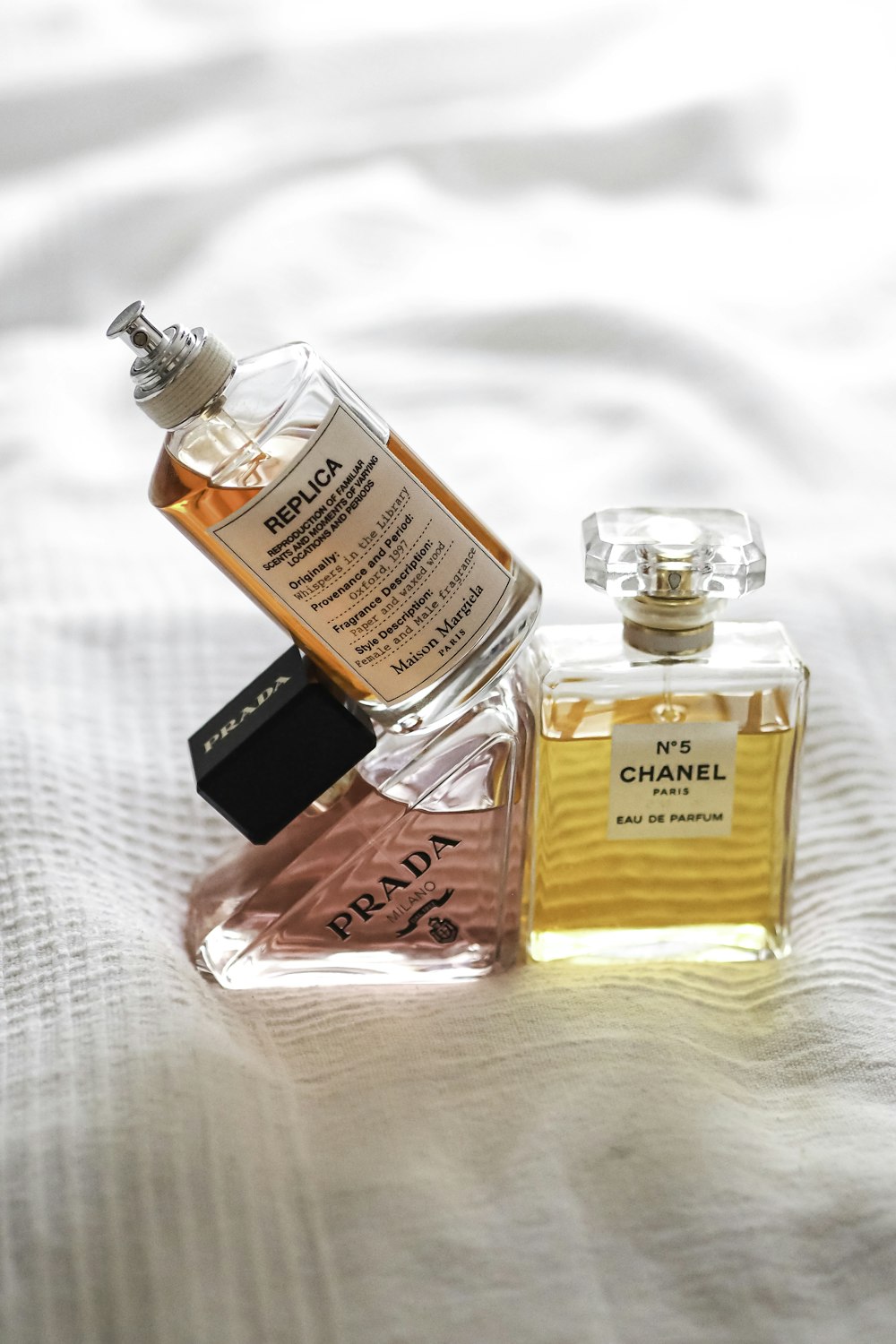 a bottle of perfume sitting on top of a bed