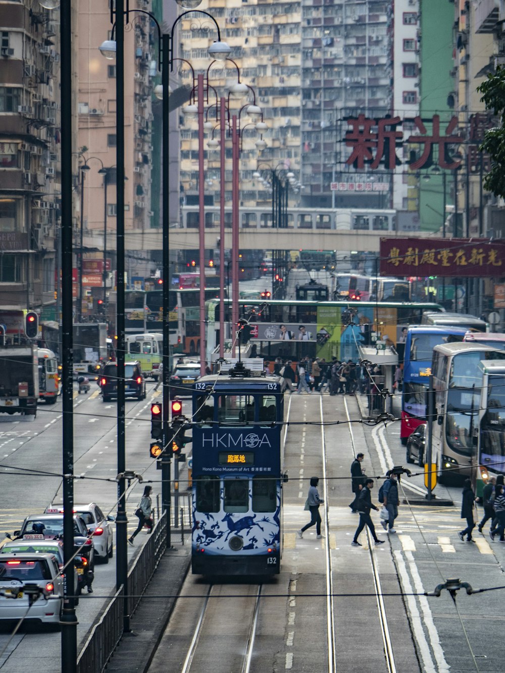 a double decker bus driving down a street next to tall buildings