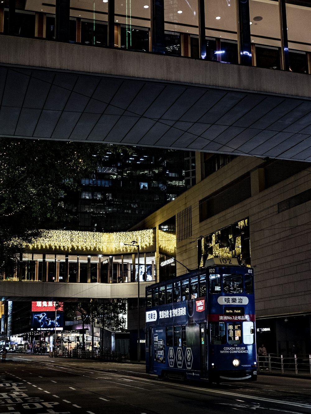 a double decker bus driving under a bridge