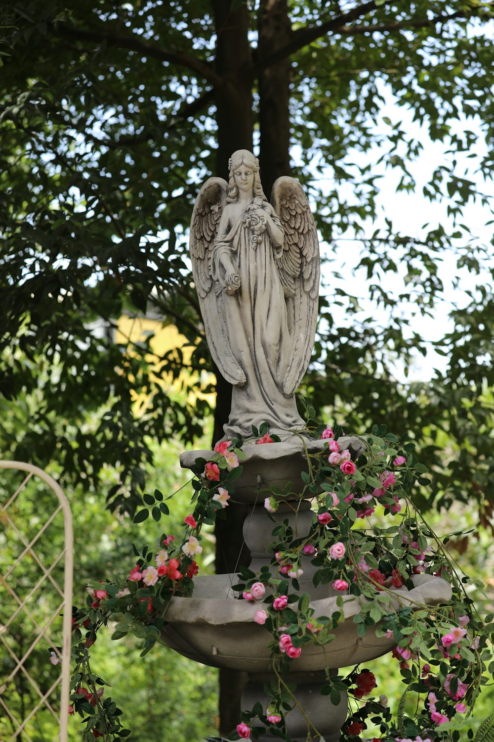 a statue of an angel surrounded by flowers