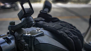Close-up of a sturdy phone mount attached to a motorcycle handlebar on a sunny day.