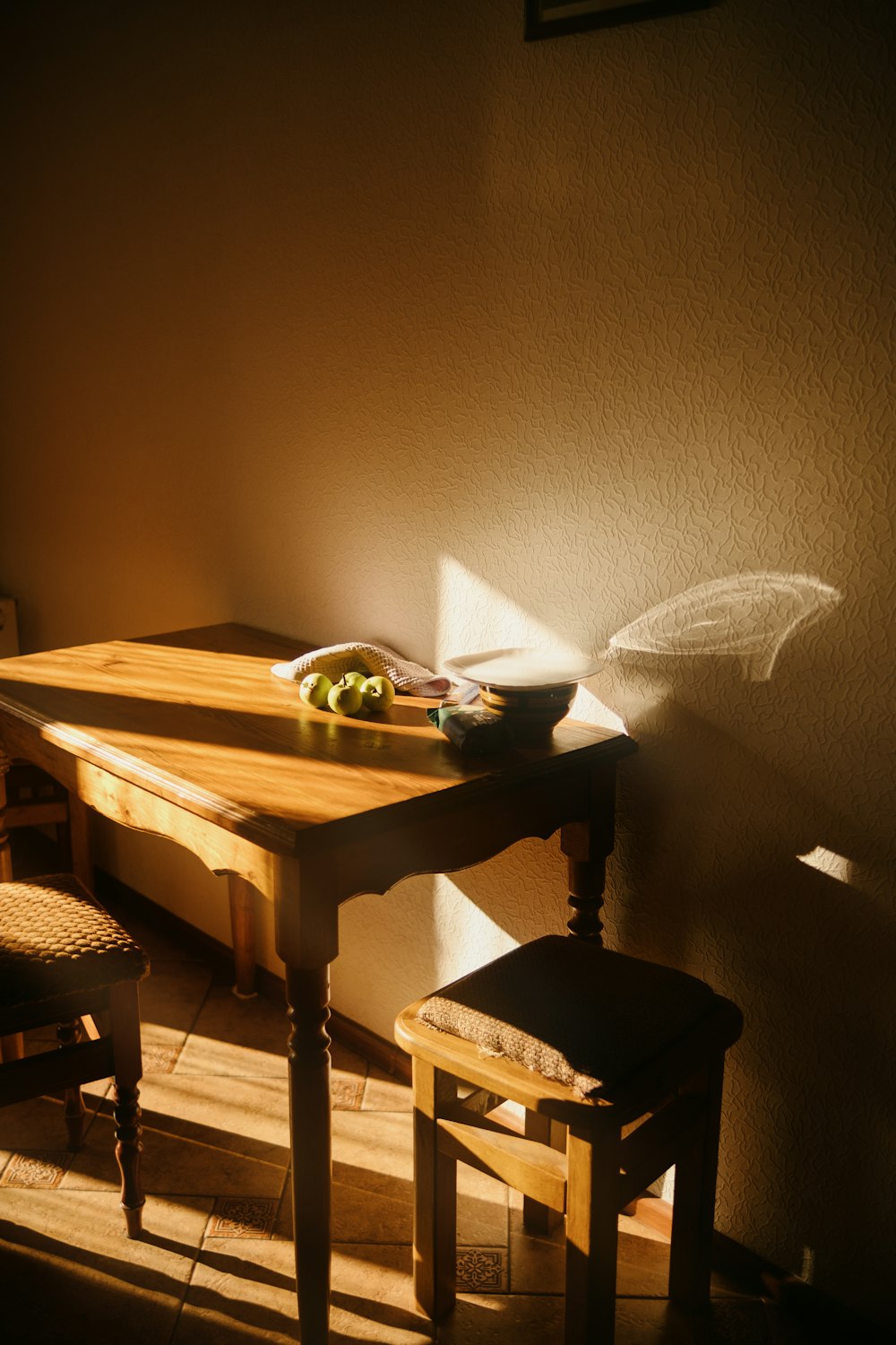 a wooden table with a bowl of fruit on top of it