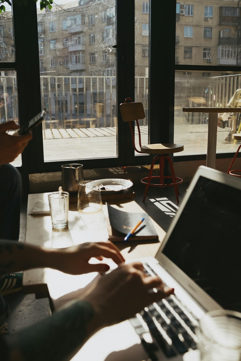 a person sitting at a table using a laptop computer