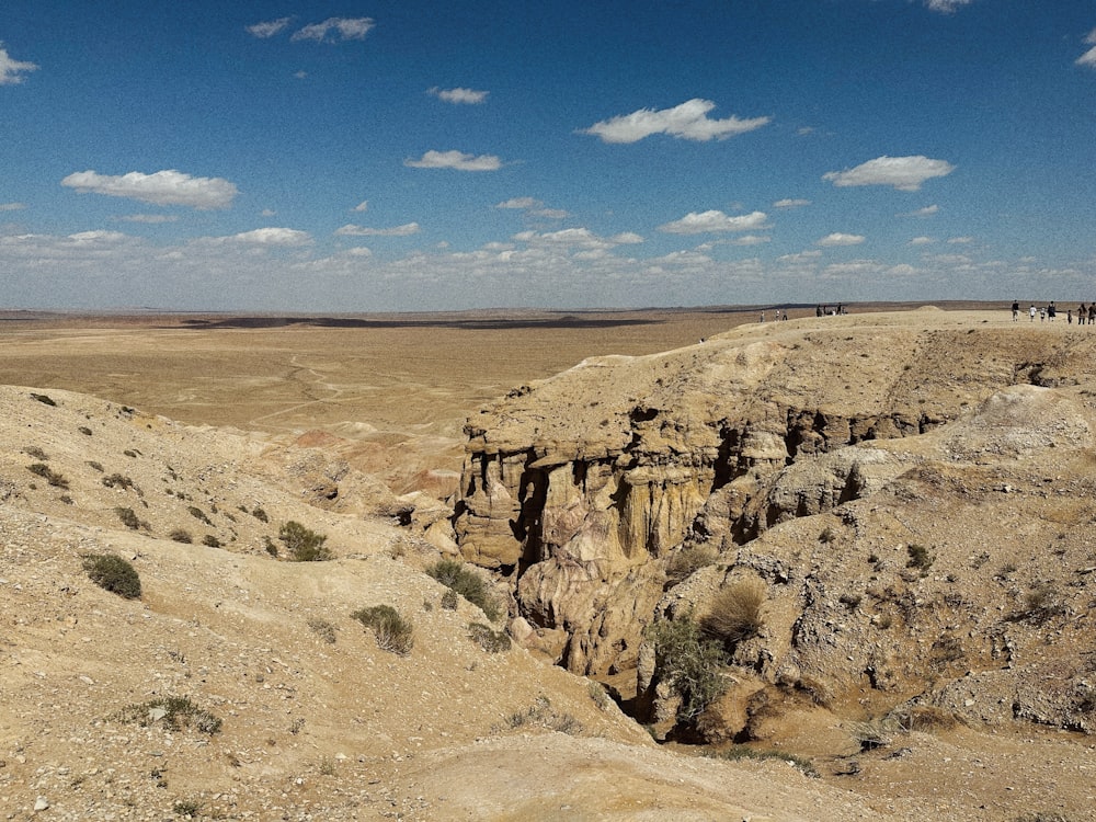 a group of people standing on top of a cliff