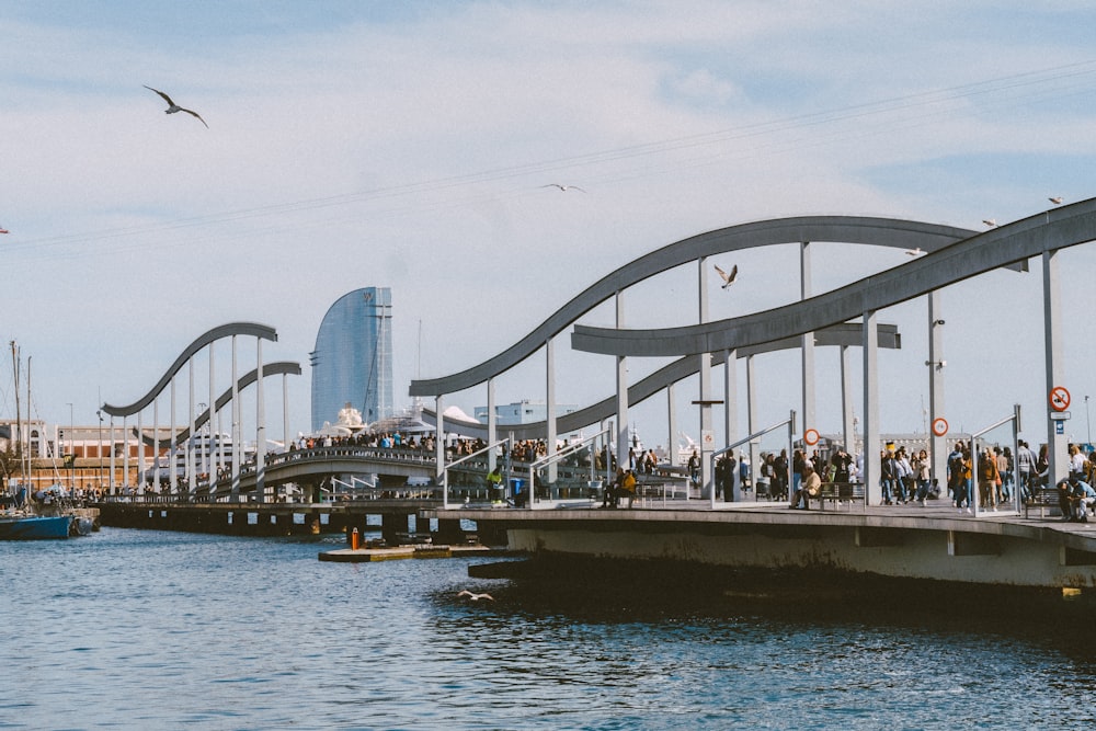 a group of people standing on a bridge over a body of water