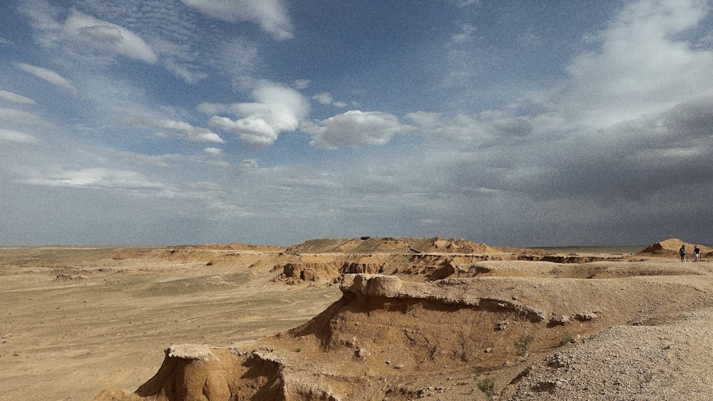 a view of a desert with a few clouds in the sky