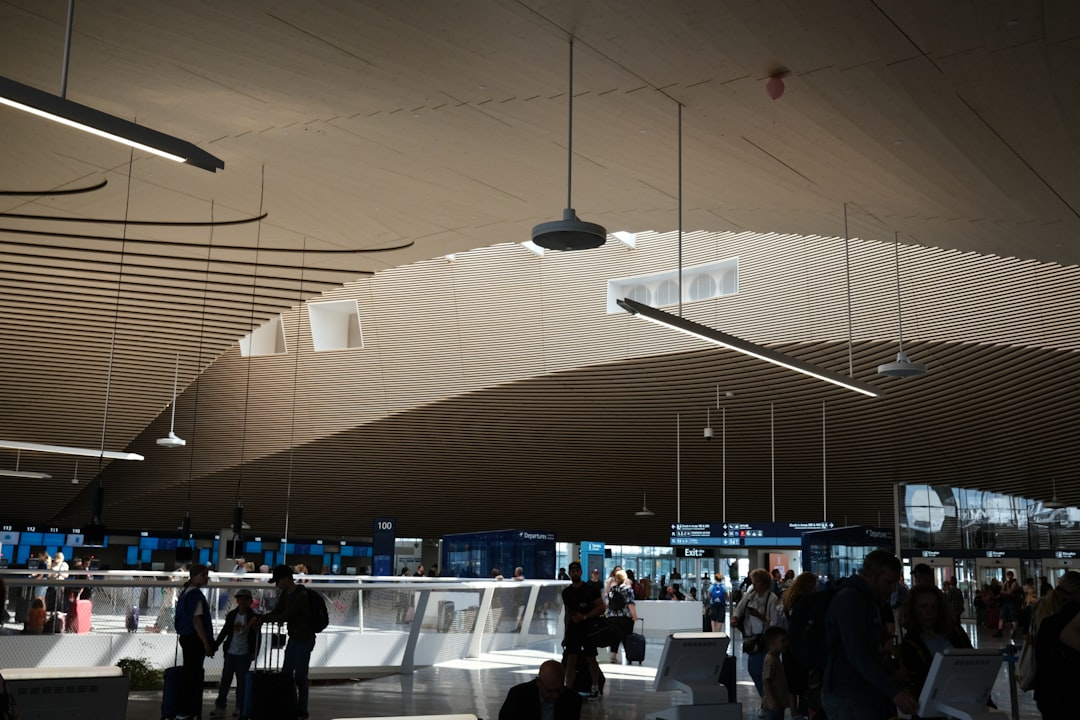 a group of people standing around a train station, Helsinki airport terminal 2023.