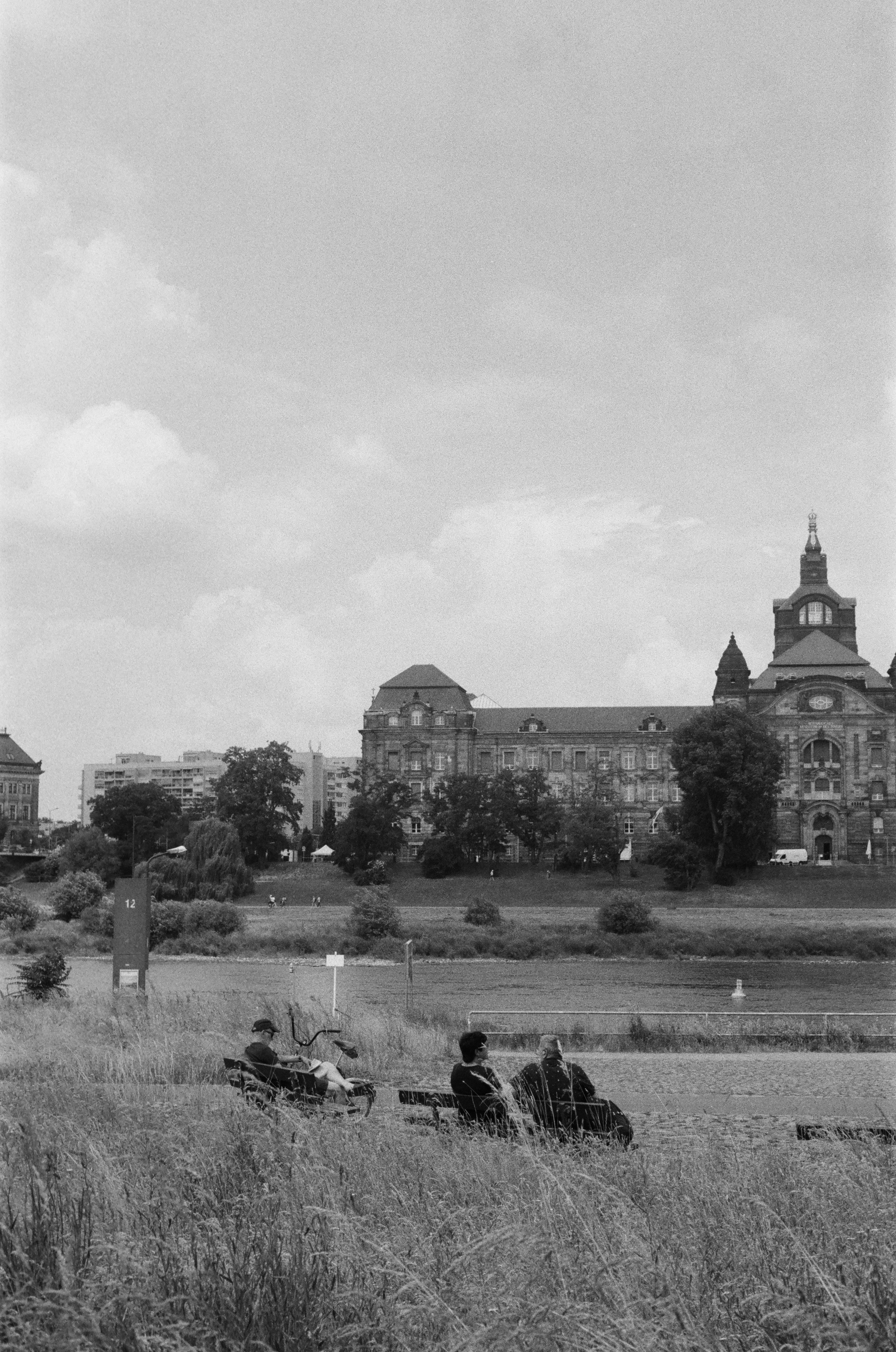 a black and white photo of people sitting in a field