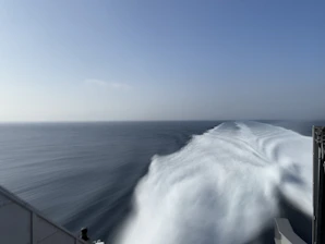 A massive oil tanker cutting through deep blue ocean waters under a clear sky, symbolizing power and reliability.