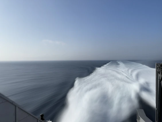A massive oil tanker cutting through deep blue ocean waters under a clear sky, symbolizing power and reliability.