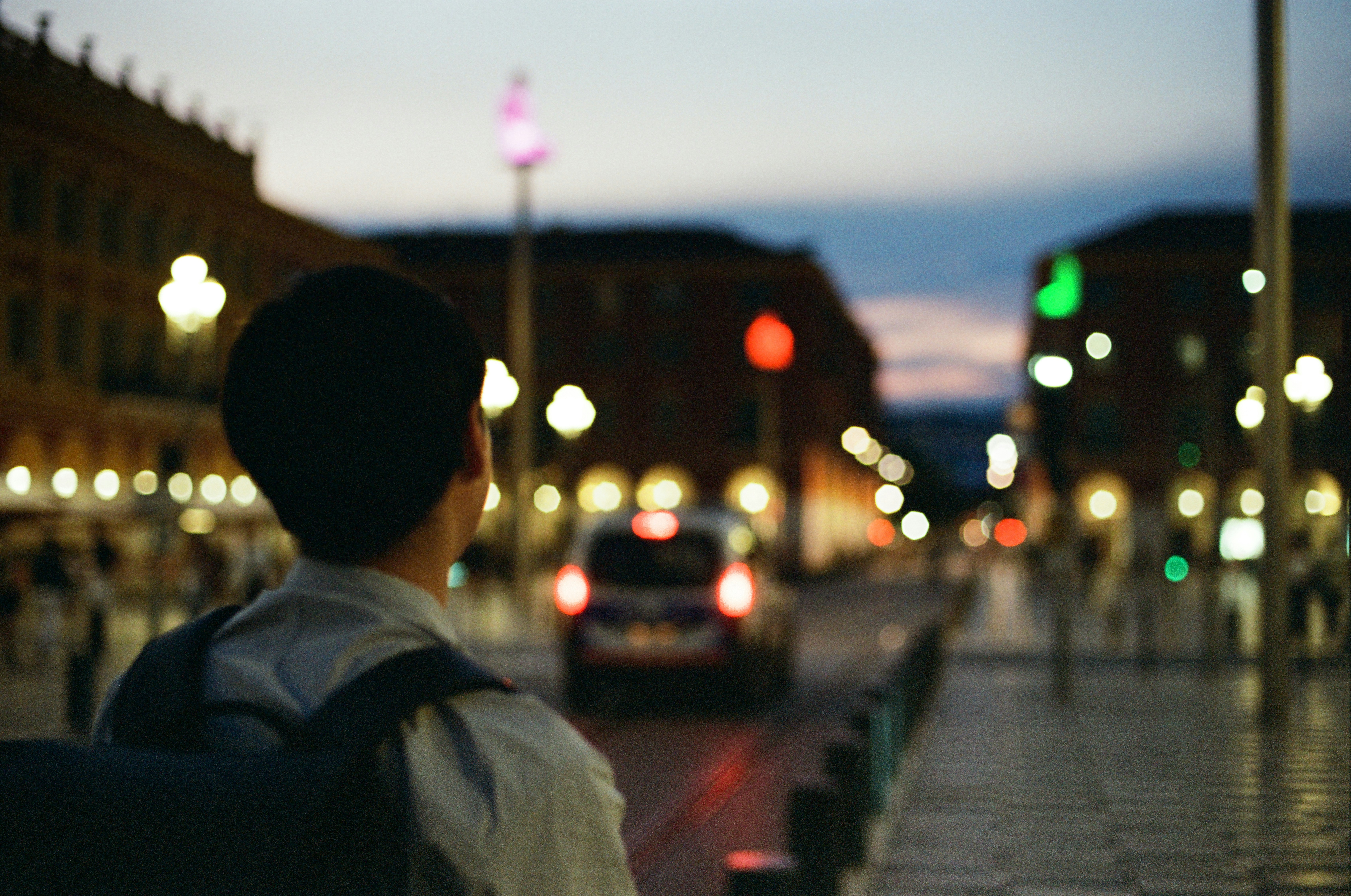 a person standing on a sidewalk with a backpack