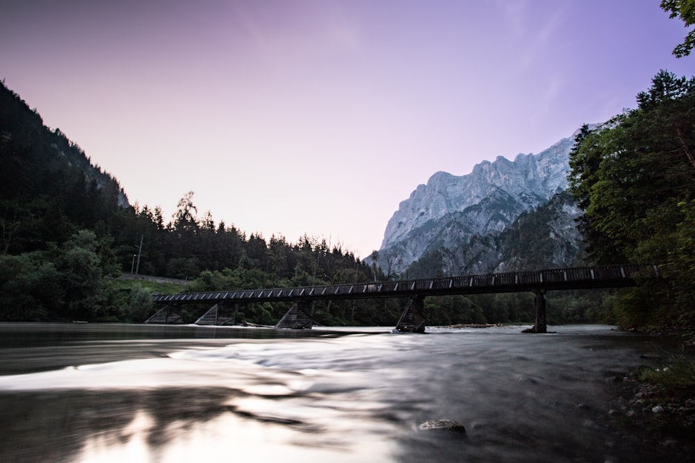 Un ponte su un fiume con le montagne sullo sfondo