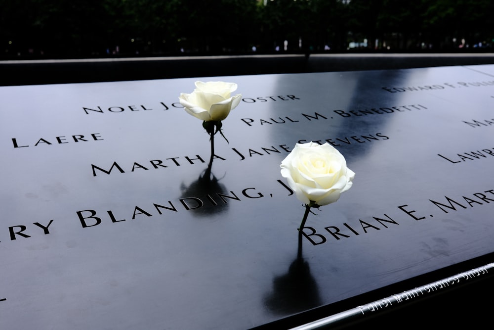 a close up of a memorial with flowers on it