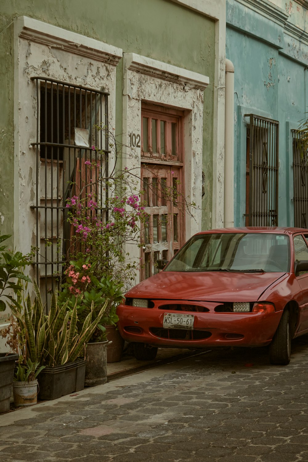 a red car parked on the side of a street