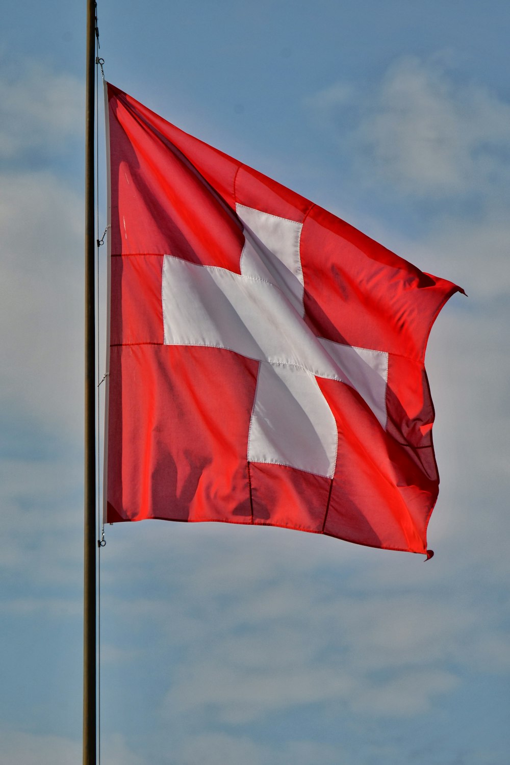 a red and white flag flying in the wind