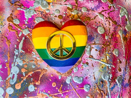 Colorful digital icons floating around a heart, illustrating love overcoming hate.
