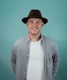 a man in a hat is smiling for the camera