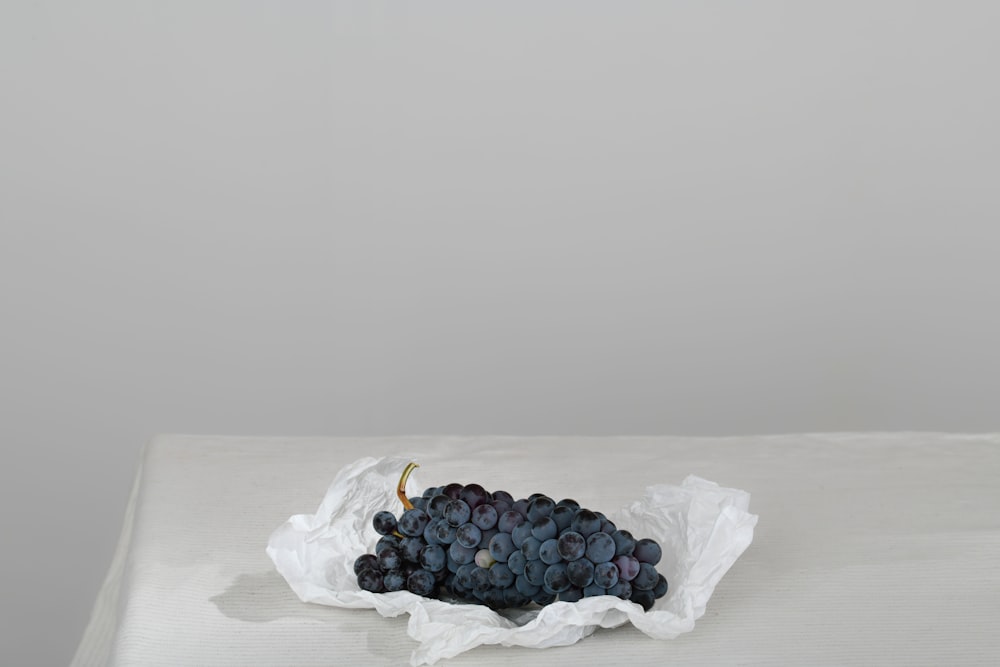 a bunch of grapes sitting on top of a white table