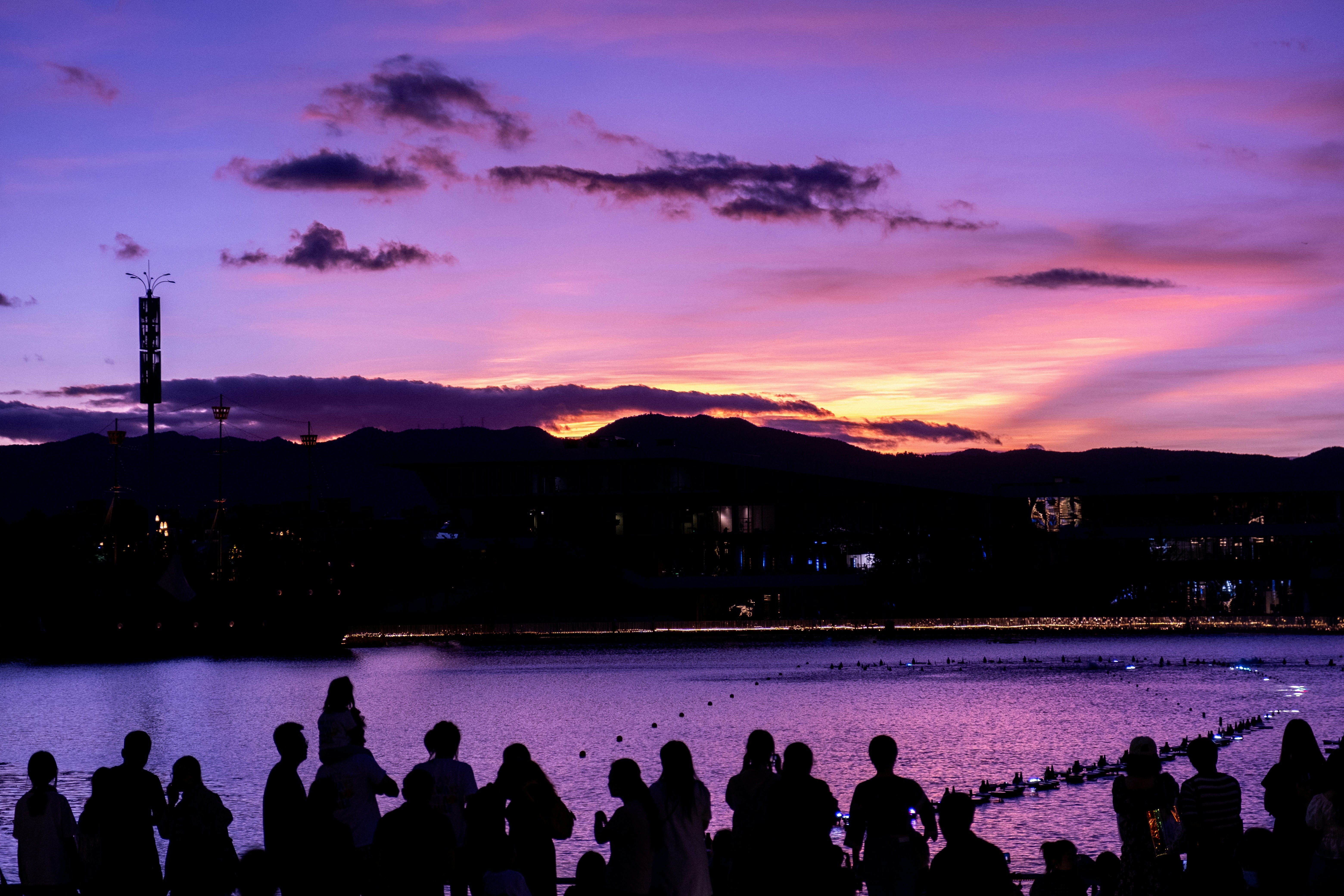 a group of people standing next to a body of water