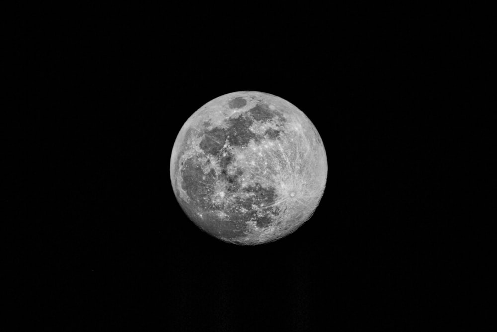 a full moon is seen in the dark sky