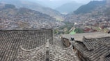 A panoramic view of a village with various roofs recently maintained by GM Toiture.