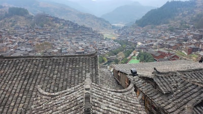 A panoramic view of a village with various roofs recently maintained by GM Toiture.