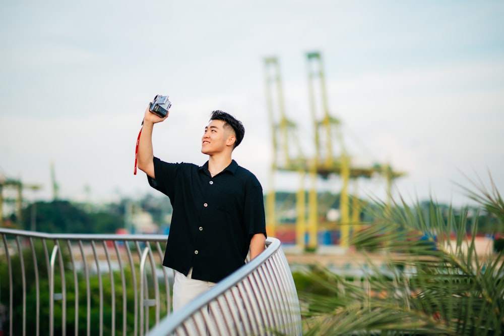 Un uomo che tiene una macchina fotografica in aria