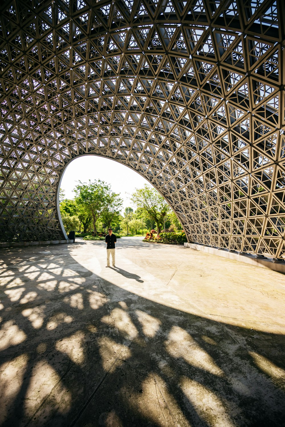 una persona in piedi sotto una grande struttura metallica