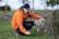 a man in an orange jacket leaning on a rock
