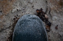 Close-up of a weathered combat boot stepping through desert terrain.