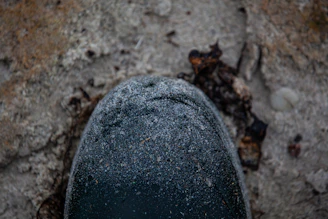 Close-up of a rugged work boot stepping on gravel, dust swirling around.