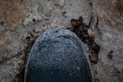 Close-up of a weathered combat boot stepping through desert terrain.