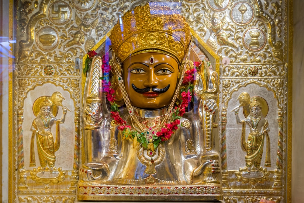 a golden statue of a person with a mustache