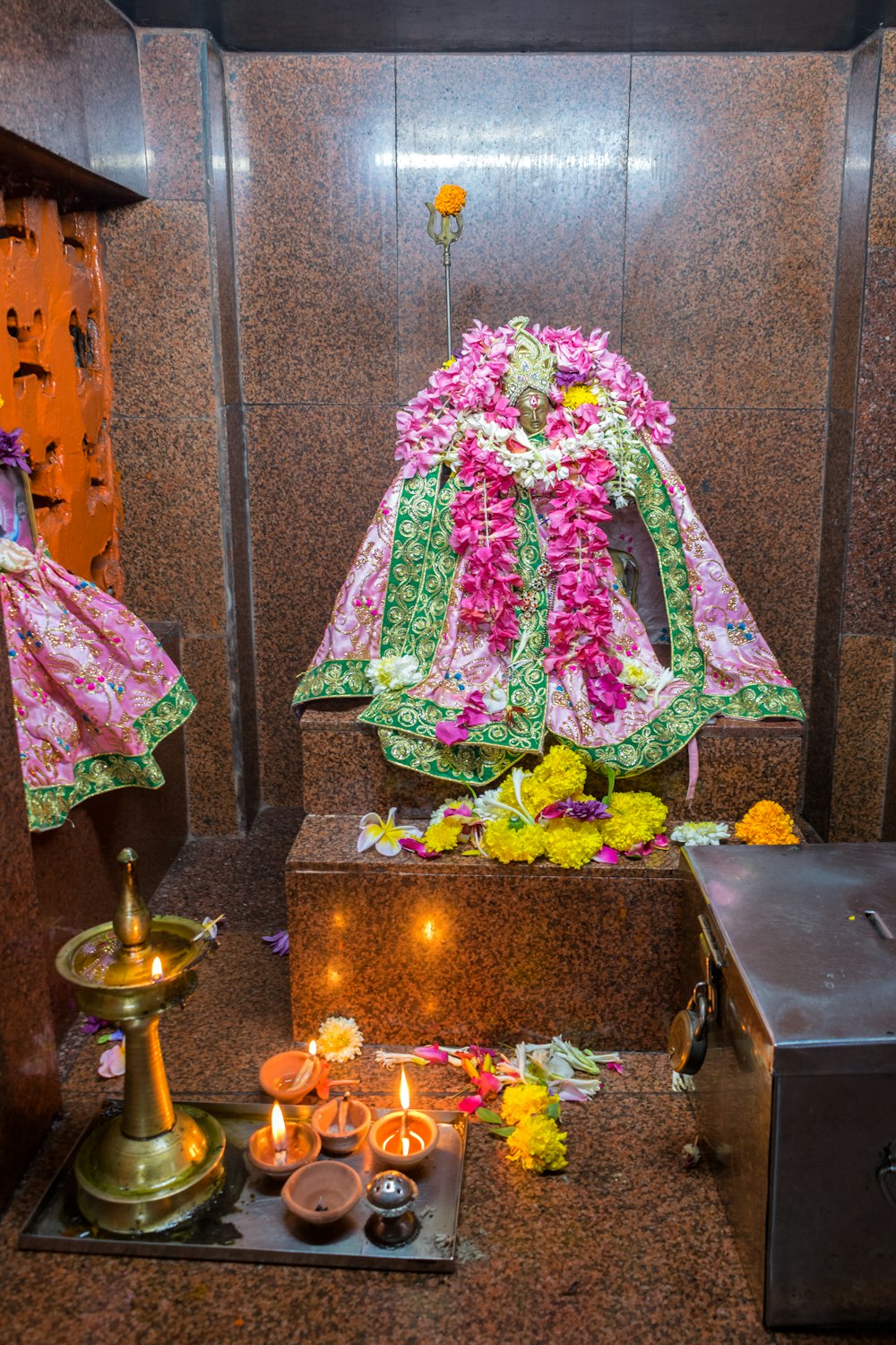 a shrine with candles and flowers on the ground