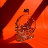 A close-up of a Laughing Dead MC Inc water bottle with a skull logo on a wooden table.